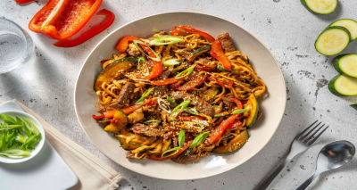 Recipe Noodles and beef stir-fry in Asian sauce prepared with zucchini and bell pepper, garnished wi